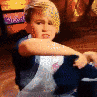 A determined kid furiously whisking a pot